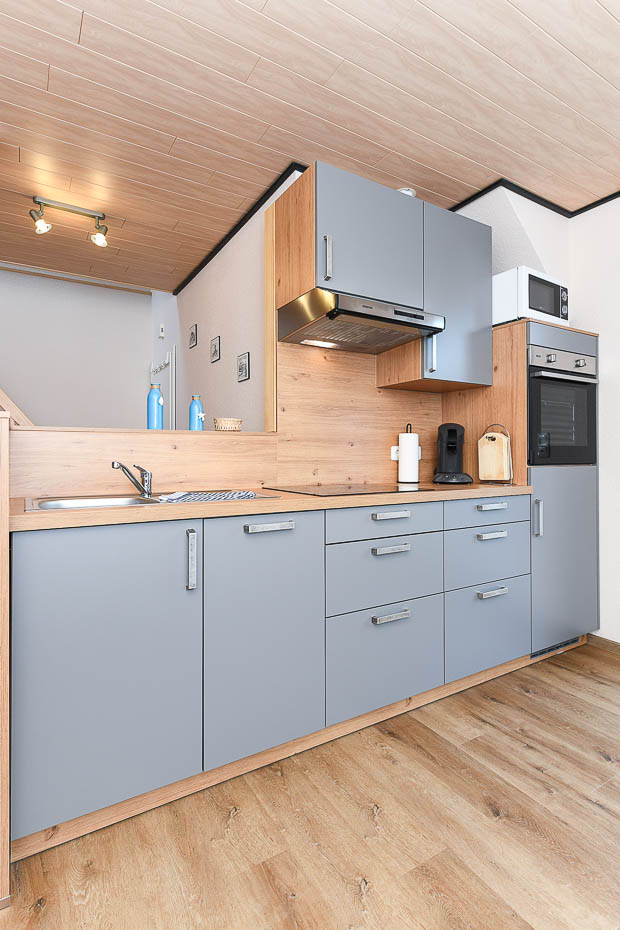 Ferienwohnung „Lee“ - Wohnzimmer mit integrierter Küche und räumlich abgeteiltem Esszimmer-Abteil