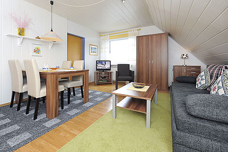 Ferienwohnung „Spiekeroog“ - Wohnraum mit integrierter Küche und Essgruppe