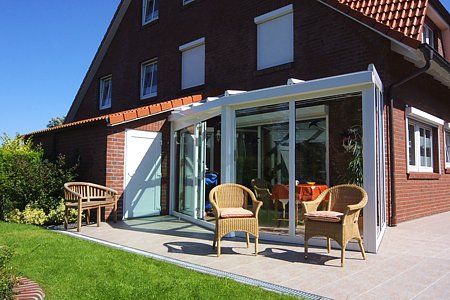 Ferienhaus „Deichkrone“ - Außenansicht mit Terrasse und Wintergarten