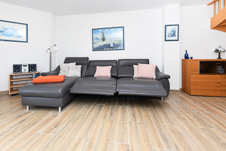 Ferienhaus „Deichkrone“ - Wohnzimmer mit angegliederter Küche und Essgruppe