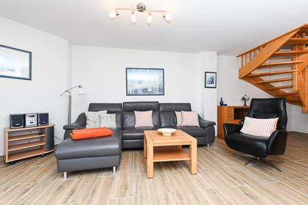 Ferienhaus „Deichkrone“ - Wohnzimmer mit angegliederter Küche und Essgruppe