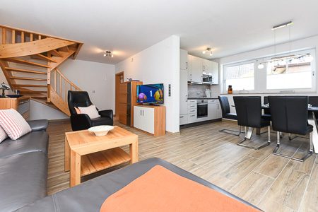 Ferienhaus „Deichkrone“ - Wohnzimmer mit angegliederter Küche und Essgruppe