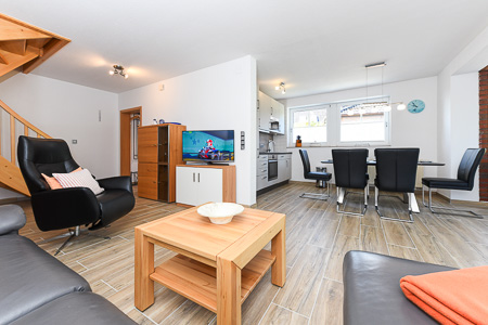 Ferienhaus „Deichkrone“ - Wohnzimmer mit angegliederter Küche und Essgruppe