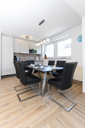 Ferienhaus „Deichkrone“ - Wohnzimmer mit angegliederter Küche und Essgruppe