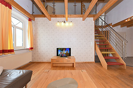 Ferienwohnung Galeriewohnung - Wohnzimmer mit separatem Küchenteil bei offener Raumgestaltung