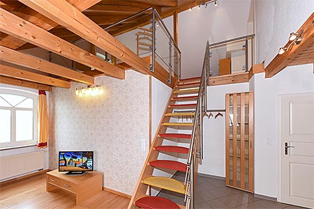 Ferienwohnung Galeriewohnung - Wohnzimmer mit separatem Küchenteil bei offener Raumgestaltung