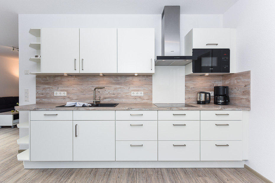 Ferienhaus „Strandperle“ - Wohnraum mit integrierter Küche und Essgruppe