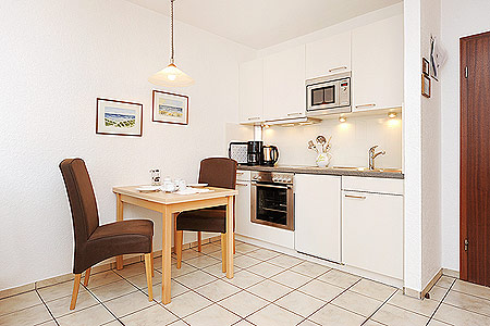 Apartment - Wohnzimmer mit integriertem Küchenbereich und Schrank-Doppelbett