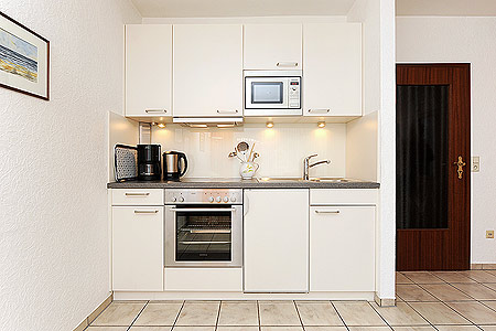 Apartment - Wohnzimmer mit integriertem Küchenbereich und Schrank-Doppelbett