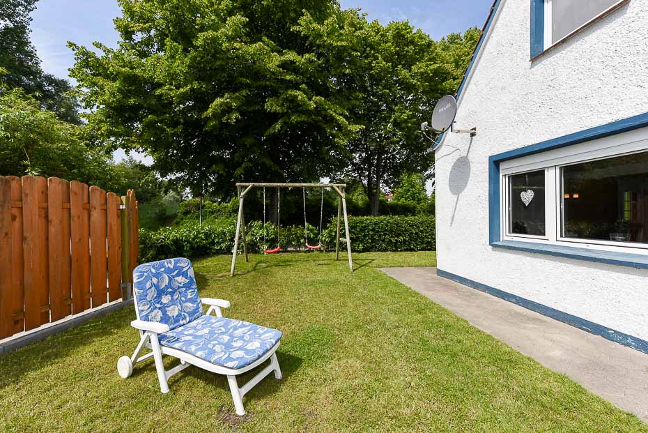 Ferienhaus „Lieblingsdüne“ - Garten mit Liegestuhl, Schaukel und Sandkasten