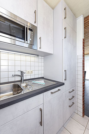 Ferienhaus „Friesenperle“ - Wohnzimmer mit räumlich abgeteilter Küchennische