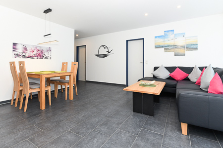 Ferienhaus „Friesenperle“ - Wohnzimmer mit räumlich abgeteilter Küchennische